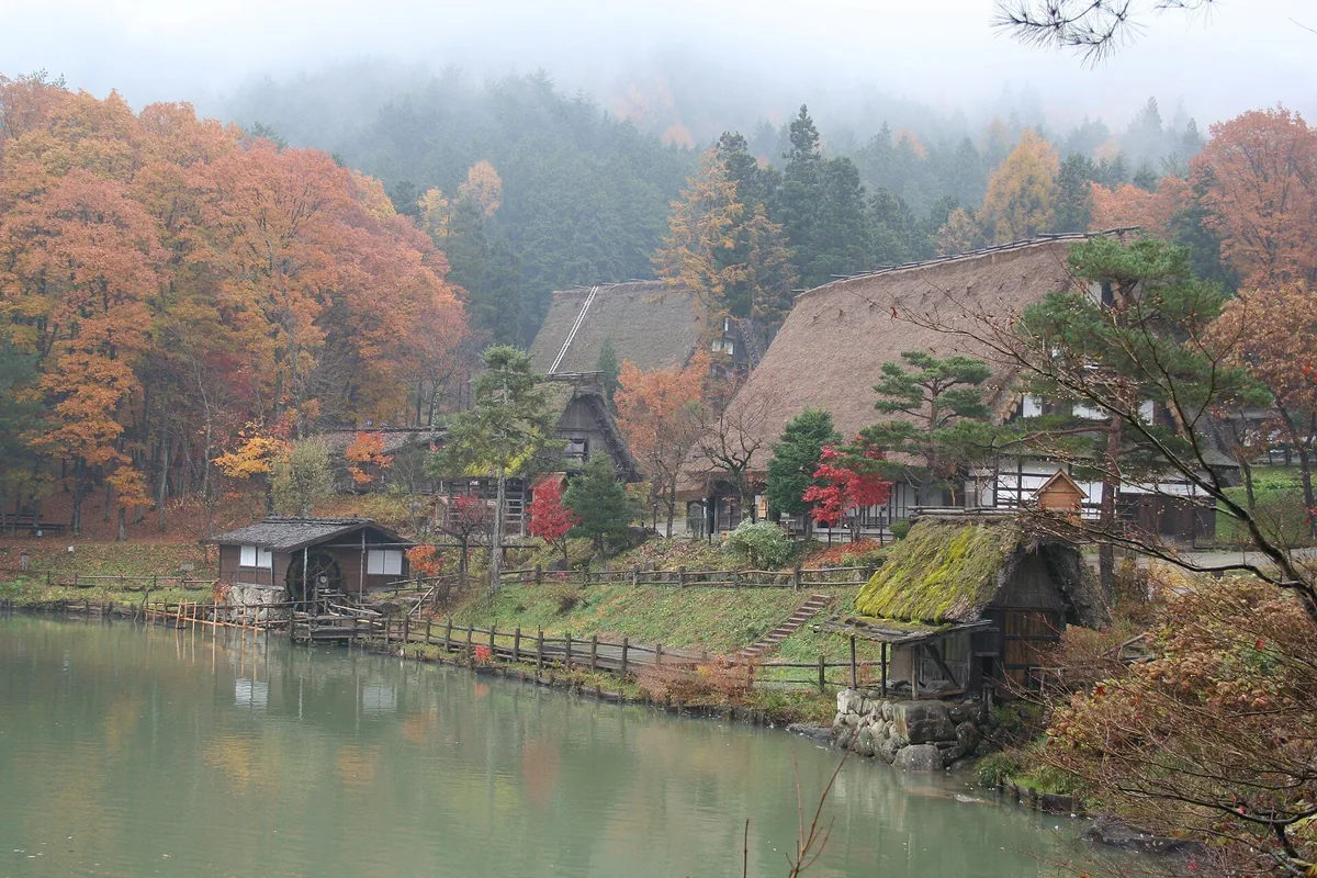 Waterwheel and traditional rural building beside the pond at Hida Folk Village
