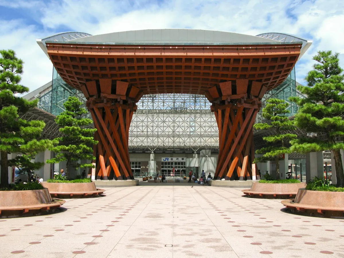 Tsuzumimon Gate and the glass entrance of Kanazawa Station under a blue sky