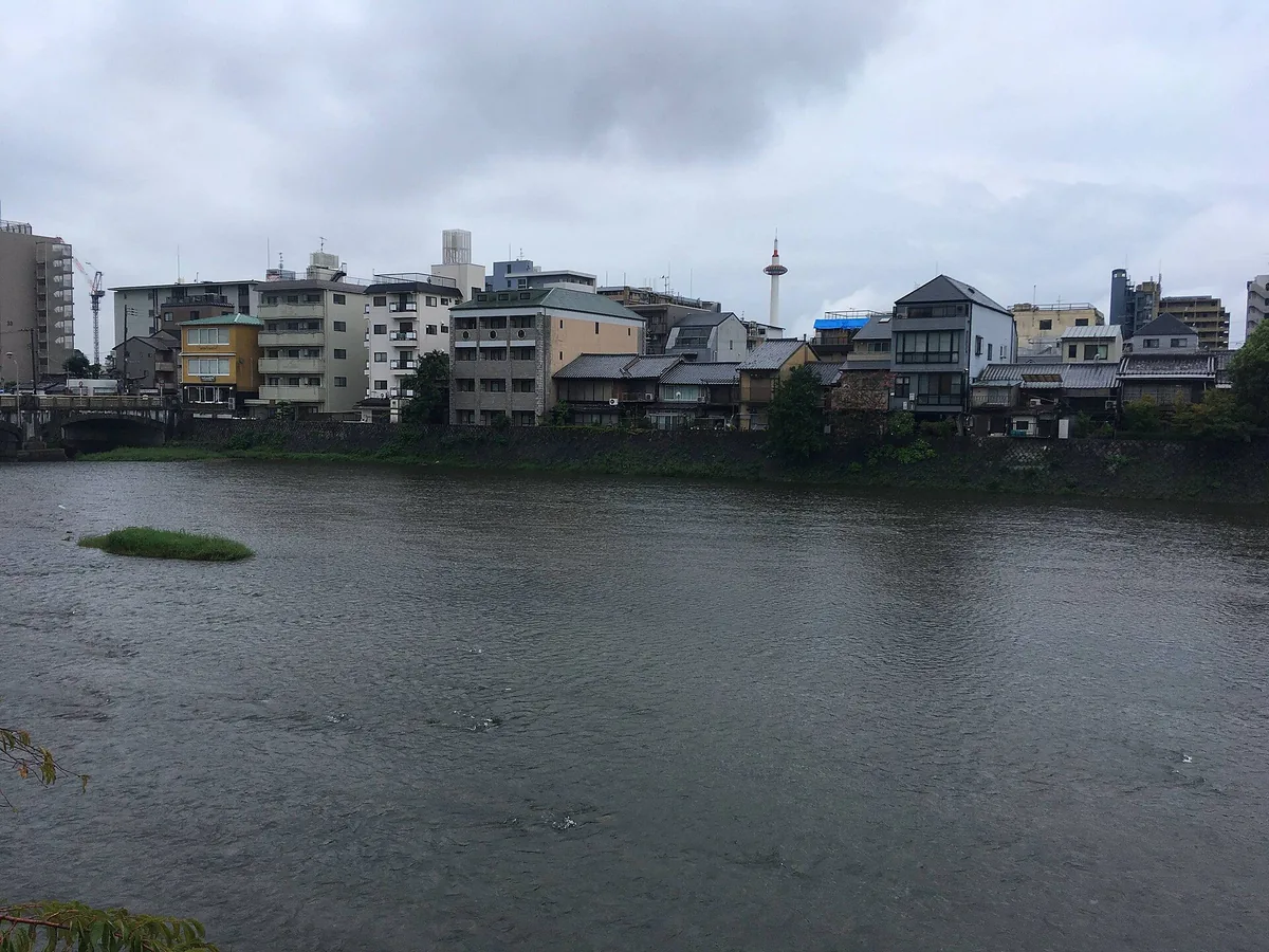 Kamo River in Kyoto with Kyoto Tower rising above the distant city