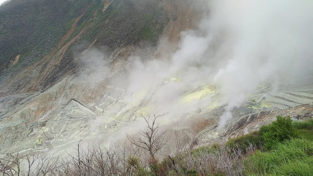 Active fumaroles releasing steam across the rocky slopes of Owakudani