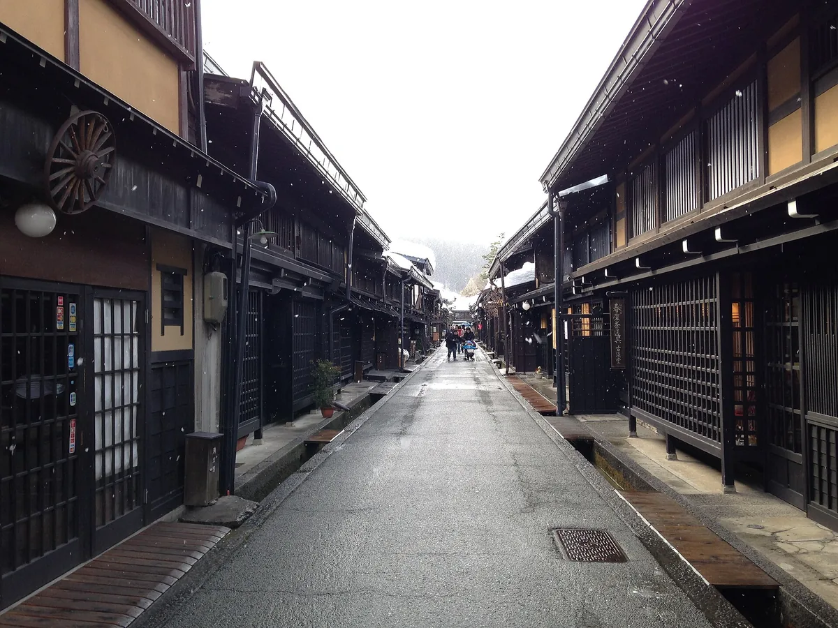 Snow-covered traditional wooden streetscape in Takayama's Sanmachi district